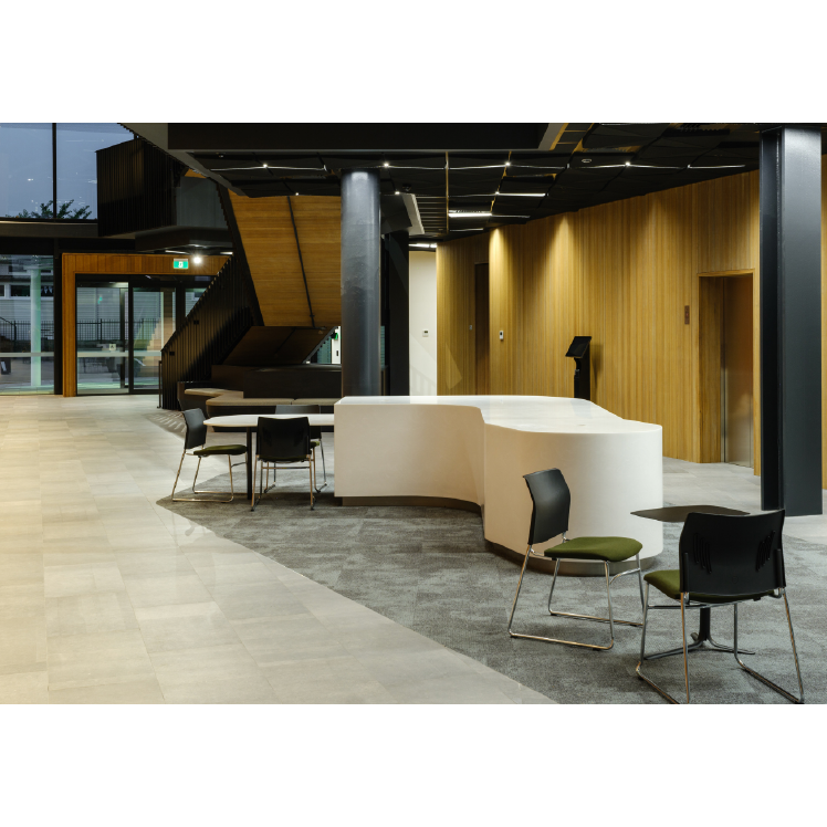 Modern interior with curved white desk and chairs in a well-lit room.